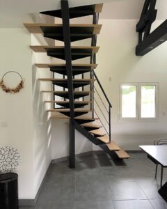 Escalier colimaçon moderne en métal noir et marches en bois clair dans un salon au design contemporain.